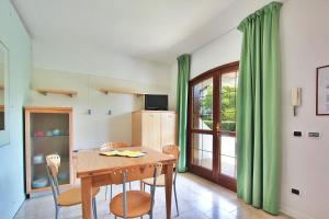 uma sala de jantar com uma mesa e cadeiras e uma janela em Aparthotel Ponza em Lignano Sabbiadoro