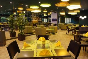 a restaurant with tables and chairs with yellow napkins at Trans World Hotel Auefeld in Hannoversch Münden