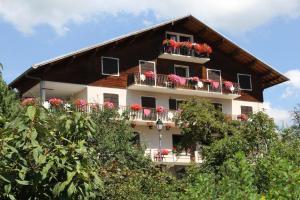 a building with red flowers on the balconies at Relais Du Charvin in Le Bouchet-Mont Charvin