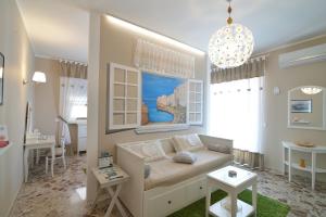 un soggiorno con divano e tavolo di Dimora Pascali Holiday - " Home & Relax " a Polignano a Mare