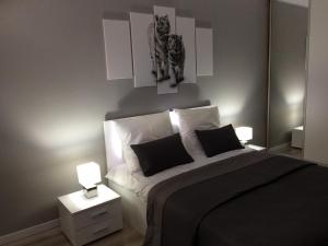 1 dormitorio con 1 cama y 2 fotos de gatos en Apartament na Ogrodach, en Poznan