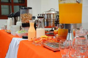 an orange table with food and drinks on it at Hotel Karlo By GHO Hoteles in Cali +57 photos