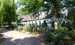 MerseloにあるHet geheim van Merseloの前に木がある白い建物