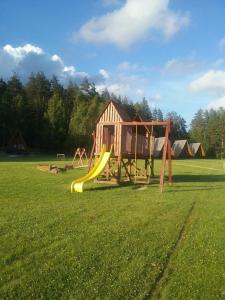 a playground with a slide in a field at Atpūtas komplekss Lakši in Usma