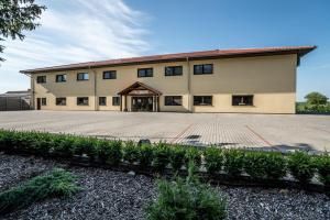 a large building with a courtyard in front of it at Hotel Na Farmě Choťovice in Choťovice