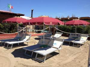 a group of chairs and umbrellas on a beach at Tavernola - Locanda Di Campagna in Battipaglia