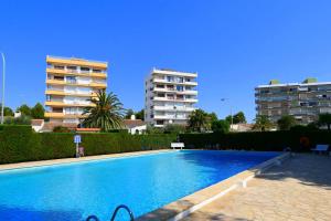 a swimming pool with two apartment buildings in the background at Rentalmar Miami Palace Plus in Miami Platja