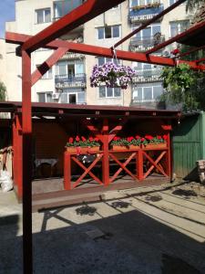 a red pergola with flowers on it in front of a building at Apartament Roza in Braşov