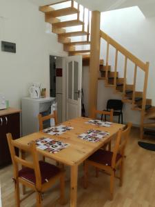 a dining room table with chairs and a staircase at Apartament Roza in Braşov