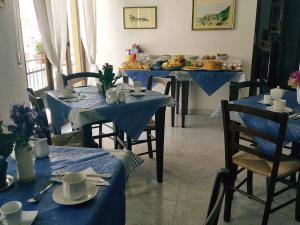 a dining room with blue tables and chairs with dishes at B&B Selvaggio Blu in Baunei