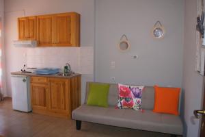a kitchen with a couch with colorful pillows on it at Stella Studios in Patitiri +68 photos