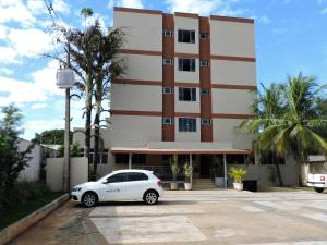 a white car parked in front of a building at Hotel Galli in Campo Grande