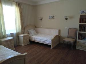 a small bedroom with a bed and a chair at Meždzirnas Country House & SPA in Kabile