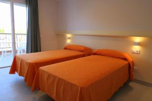 two beds in a hotel room with orange sheets at Rentalmar Miami Palace Plus in Miami Platja +41 photos
