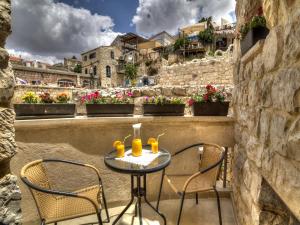 a table and chairs on a balcony with flowers at Nofesh Baatika in Safed