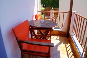 a wooden table and two chairs on a balcony at Stella Studios in Patitiri