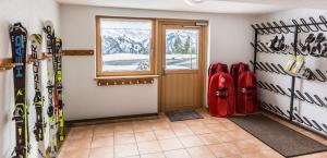 a room with a bunch of skis on the wall at Haus Annette in Schröcken