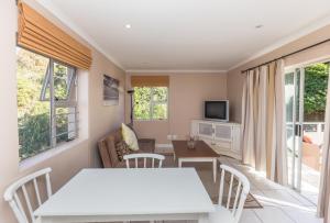 sala de estar con mesa blanca y sillas en Plett's Life, en Plettenberg Bay