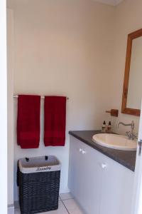 a bathroom with red towels and a sink at Plett's Life in Plettenberg Bay