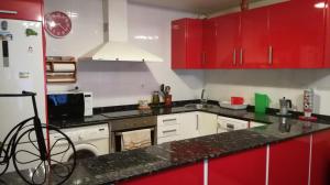 een keuken met rode kasten en een aanrecht bij Casa Paxixa in Sant Jaume d'Enveja