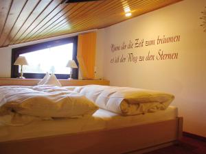 ベルヒテスガーデンにあるHaus Hombergのベッドルーム1室(壁に引用符が付いたベッド1台付)