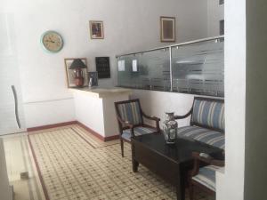 a living room with two chairs and a table and a clock at Point du Jour in Casablanca