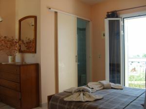 a bedroom with a bed and a dresser and a mirror at Gouna's Aparts in Xi