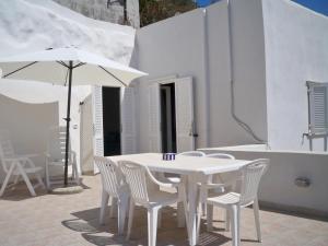 ポンツァにあるL'Isolana Case Vacanza Azzurraの白いテーブル(白い椅子、傘付)