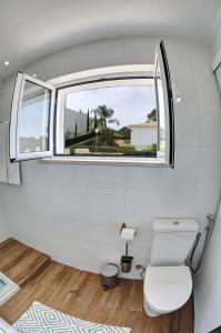 ein Badezimmer mit Toilette und Fenster in der Unterkunft 3 Villas - Praia da Falesia in Albufeira