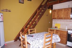 a kitchen with a dining room table and a staircase at La Posada de Damian in San Clemente del Tuyú