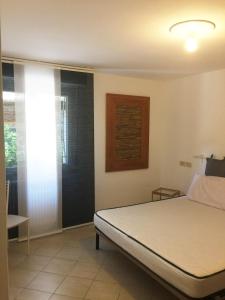 een slaapkamer met een bed en een raam bij Miramare Beach Apartment in Rimini