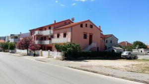 una casa rosa al lado de una calle en Apartments Marija, en Zadar