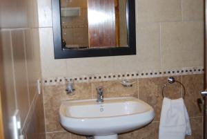 y baño con lavabo blanco y espejo. en La Posada de Damian en San Clemente del Tuyú