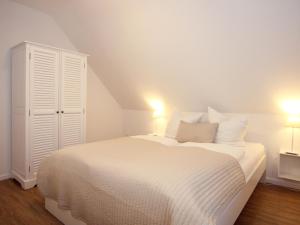 ティメンドルファー・シュトラントにあるFerienwohnung Koje 44のベッドルーム1室(白いベッド1台、照明2つ付)