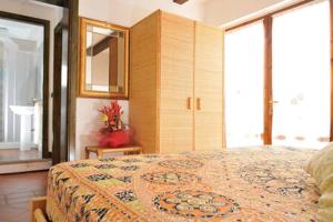 a bedroom with a large bed with a mirror and windows at Mare&relax in Santa Maria Navarrese