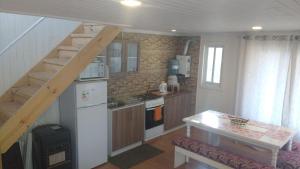 a small kitchen with a staircase in a house at Cabañas Felipe in Pichilemu +24 photos