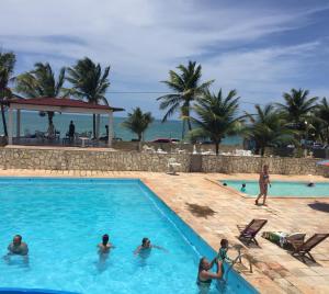 um grupo de pessoas na piscina de um resort em Beach Hotel Jacuma em Jacumã