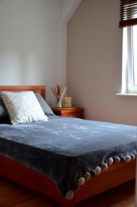 a bedroom with a bed with a blue blanket on it at Apartament sopot 2 pokoje in Sopot