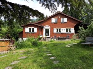 a red brick house with a pathway in front of it at Chalet Chic mit Hot Pot in Wildhaus