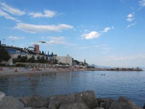 a group of people swimming in the water at a beach at Apartment Massimo in Rijeka