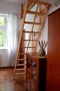 a wooden staircase in a living room with a table at Apartament sopot 2 pokoje in Sopot