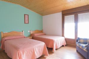 a bedroom with two beds and a window at Casa Codesal in Noalla