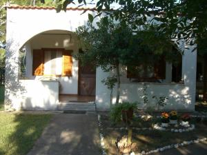 ein weißes Haus mit einem Baum davor in der Unterkunft Garden Bungalow Valentina in Stavros