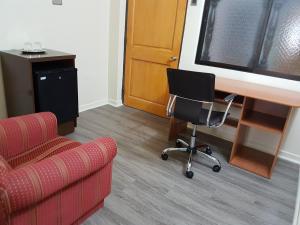 a room with a couch and a desk and a chair at Hotel Diego de Almagro Antofagasta Express in Antofagasta