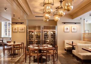 a restaurant with tables and chairs and chandeliers at 21c Museum Hotel Cincinnati in Cincinnati