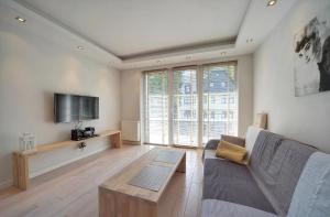 sala de estar con sofá y TV en Apart-Invest Apartamenent Bergen en Szklarska Poręba