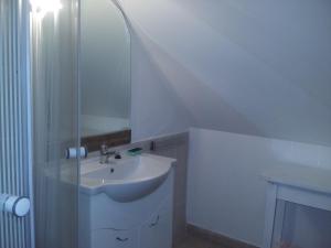a white bathroom with a sink and a mirror at GESZTENYÉS Vendégház in Harkány