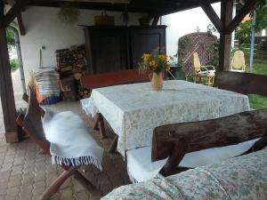 uma mesa com cadeiras e um vaso de flores sobre ela em GESZTENYÉS Vendégház em Harkány