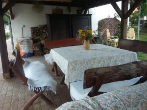 "ハルカーニャ"にあるGESZTENYÉS Vendégházのテーブルと椅子、花瓶