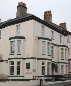 uma casa branca com uma guarnição verde em Kimberley House em Whitby